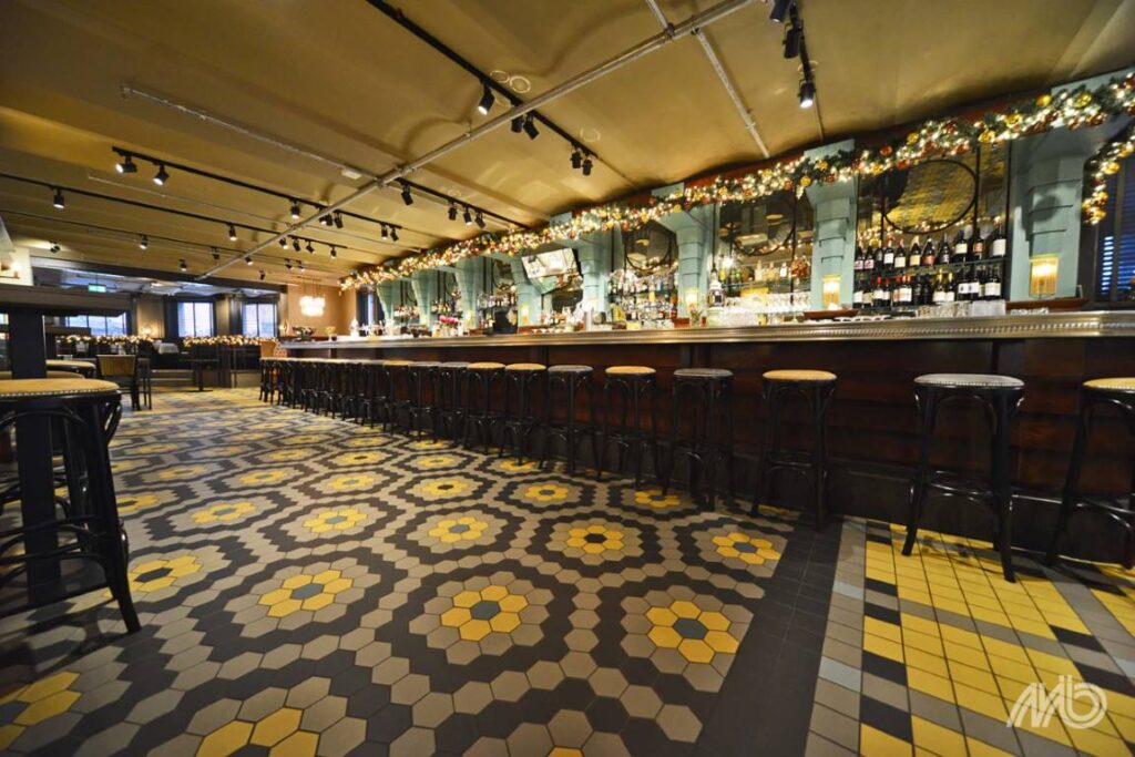 Winckelmans zeshoekige tegels in geel en grijs op de vloer van een bar