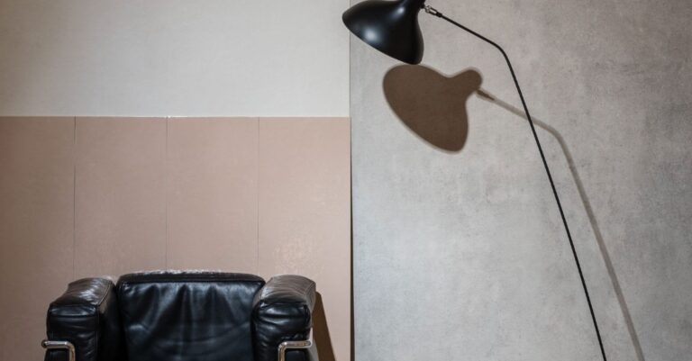 Gigacer Le Corbusier tegels in roze en lichtgrijs naast een leren fauteuil