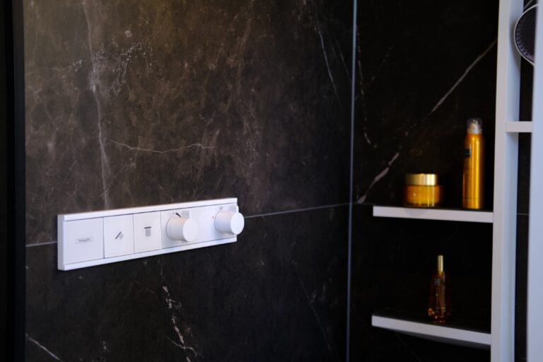 Inbouwthermostaat in een douche met donkere marmerlook tegels in de showroom