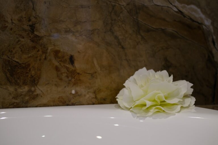 Vrijstaand ligbad voor een wand met marmerlook tegels in de showroom