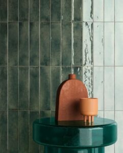 Groene glanzende wandtegels achter een groene bijzettafel
